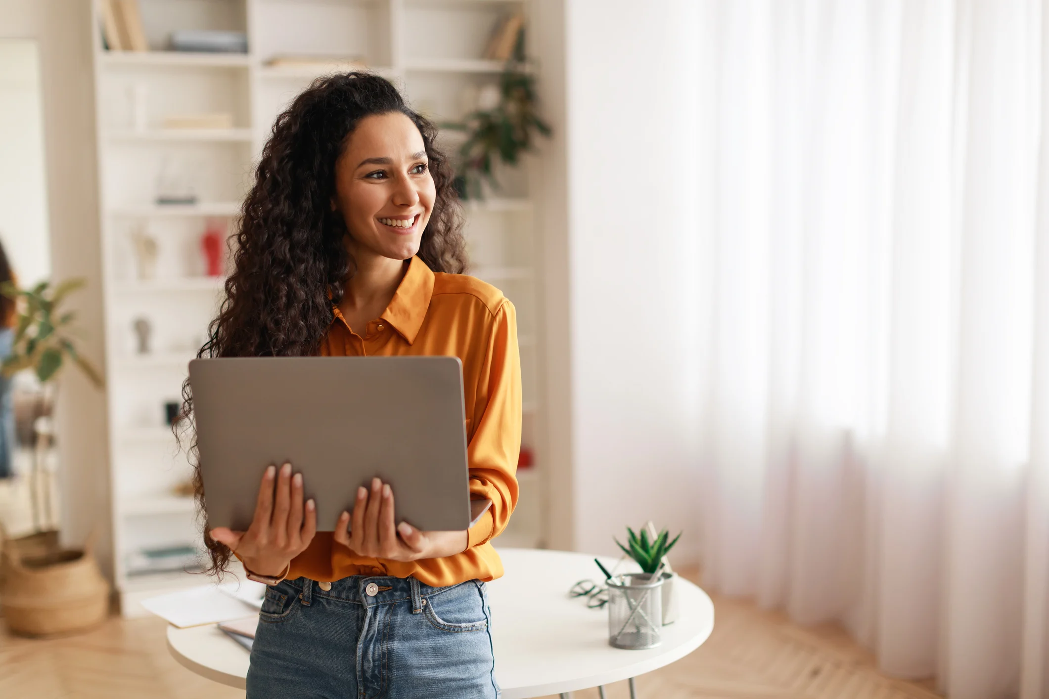 Woman Holding Laptop Working Online Standing Looking Aside Smiling Indoor 151bccb1a96ac03e97d5679f57defe79881164cd