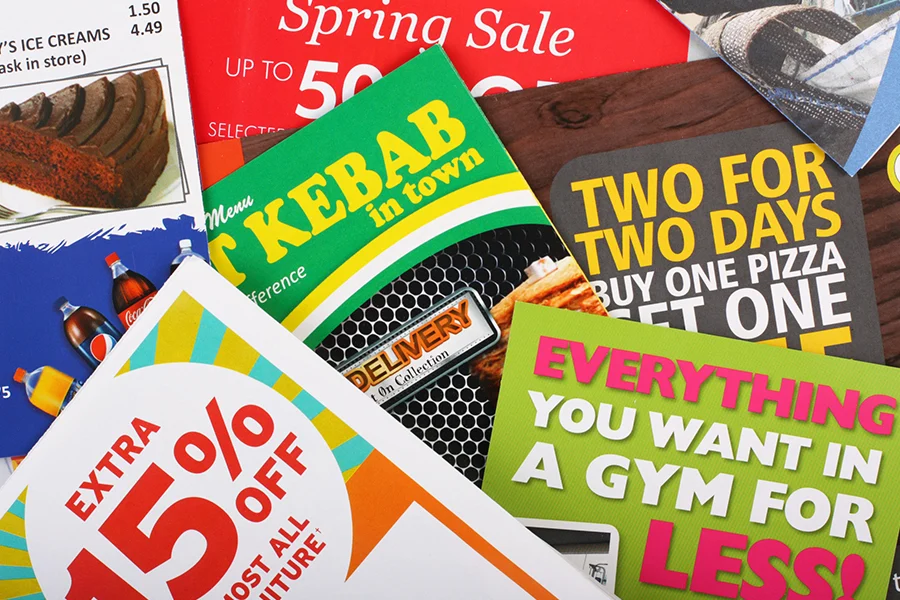 a collection of colorful promotional flyers showcasing discounts and offers, illustrating the advantages of direct mail advertising in attracting customers