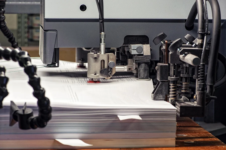 a high-speed printing machine processing bulk mail, representing direct mail promotions for marketing campaigns