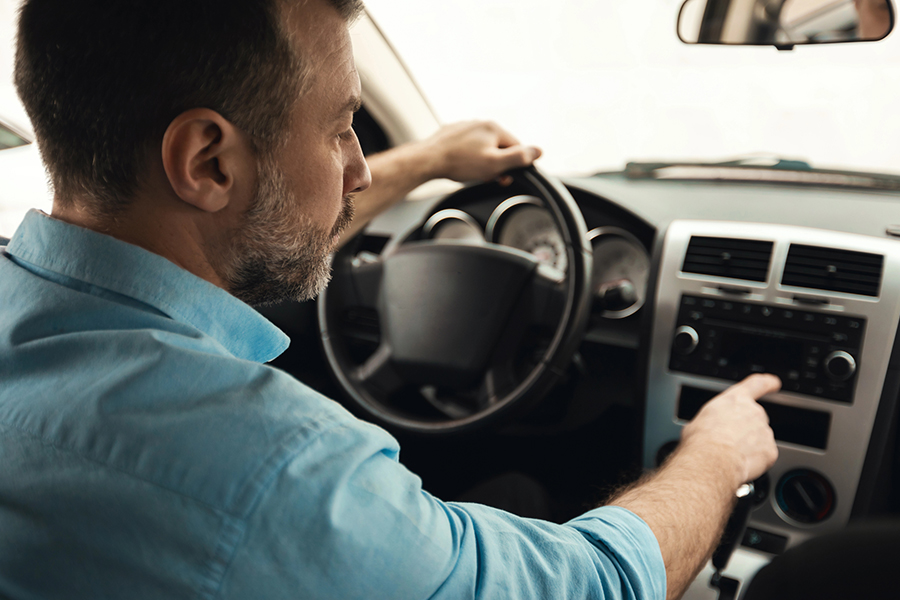 A person driving a car and listening to a satellite radio
