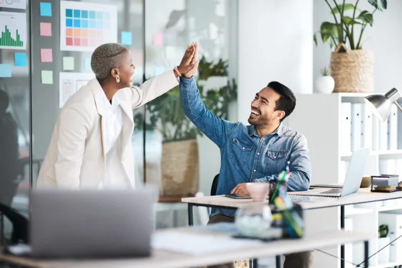 guy and girl high-fiving after using our wordpress website enhancement services on their wp site