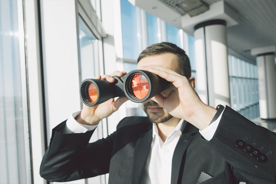 Business man looking through a binocular concept image on how to find franchise owners