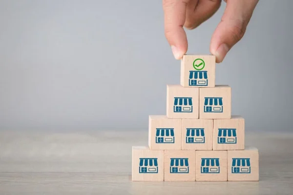 putting blocks with a franchise icon on top concept image for franchise growth & brand cohesion with a perfect marketing strategy