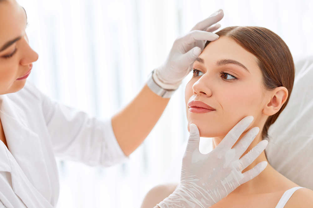 a dermatologist looking at a person's face, a concept image for how dermatology content marketing increases patient acquisition