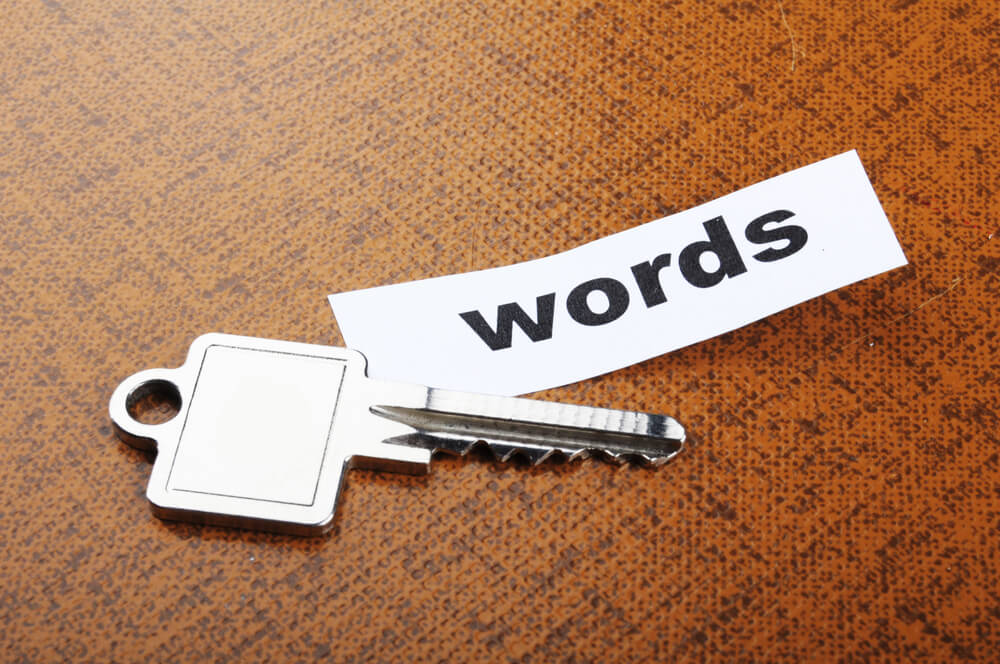 a key and paper with words typed out to depict local seo keywords