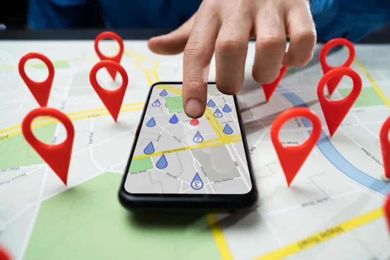 Best Franchise Marketing Campaigns: Top Strategies For Success &Amp;Amp; Examples 3 a person pointing at google maps on their phone to showcase multiple franchise locations and their local marketing campaigns