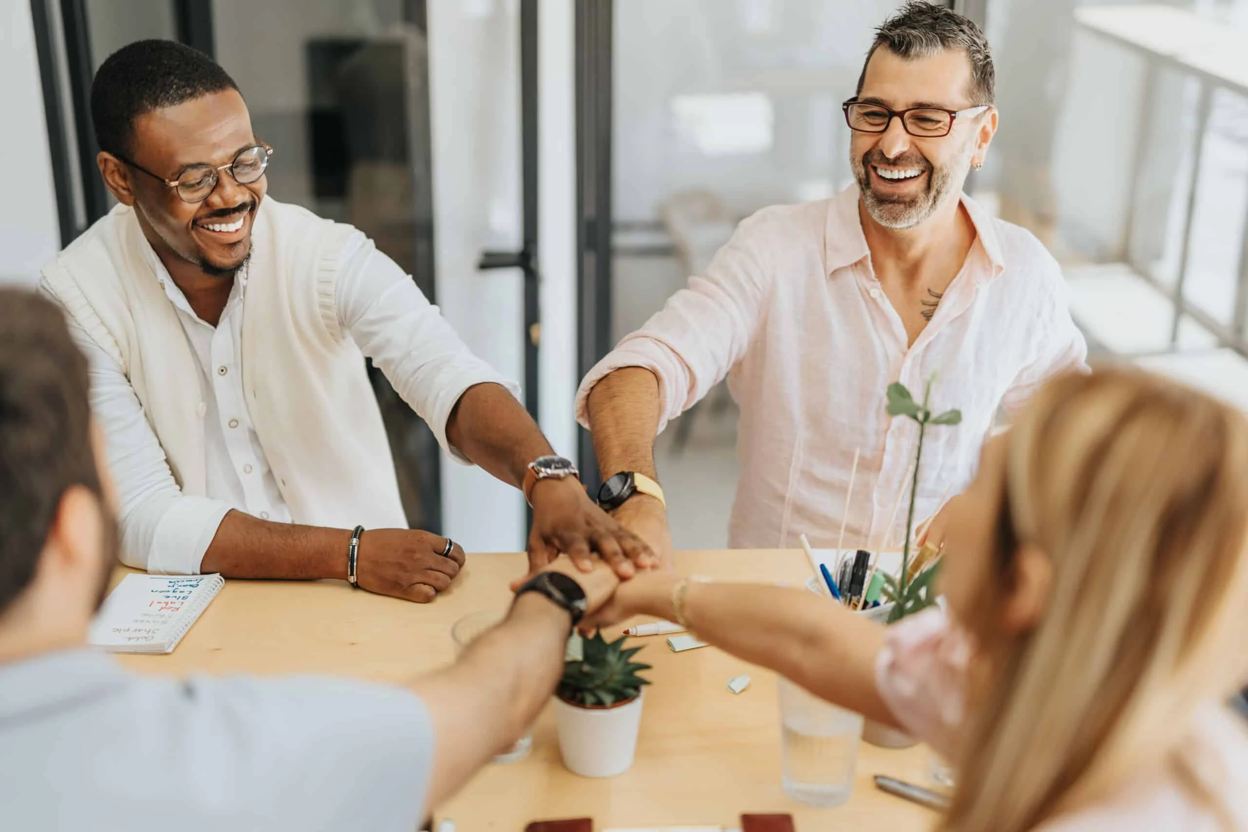 Successful Employees Putting Hands Together. team celebrating after launching a successful multi-location content marketing campaign