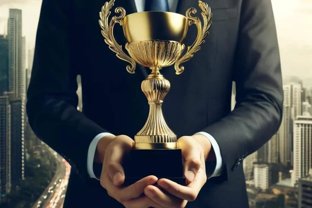 Man In Suit Who Received A Trophy For Creating The Best Franchise Marketing Campaigns man in suit holding up a large trophy he received for creating the best franchise marketing campaigns