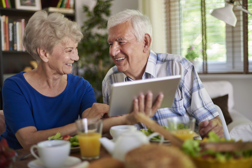 Digital marketing timeline for assisted living Featured image - Older adults using a laptop to find senior living communities.