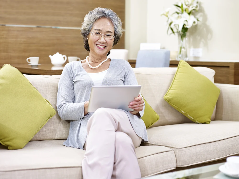 Woman-Accessing-Mobile-Version-Of-A-Website-On-A-Tablet responsive senior living website design